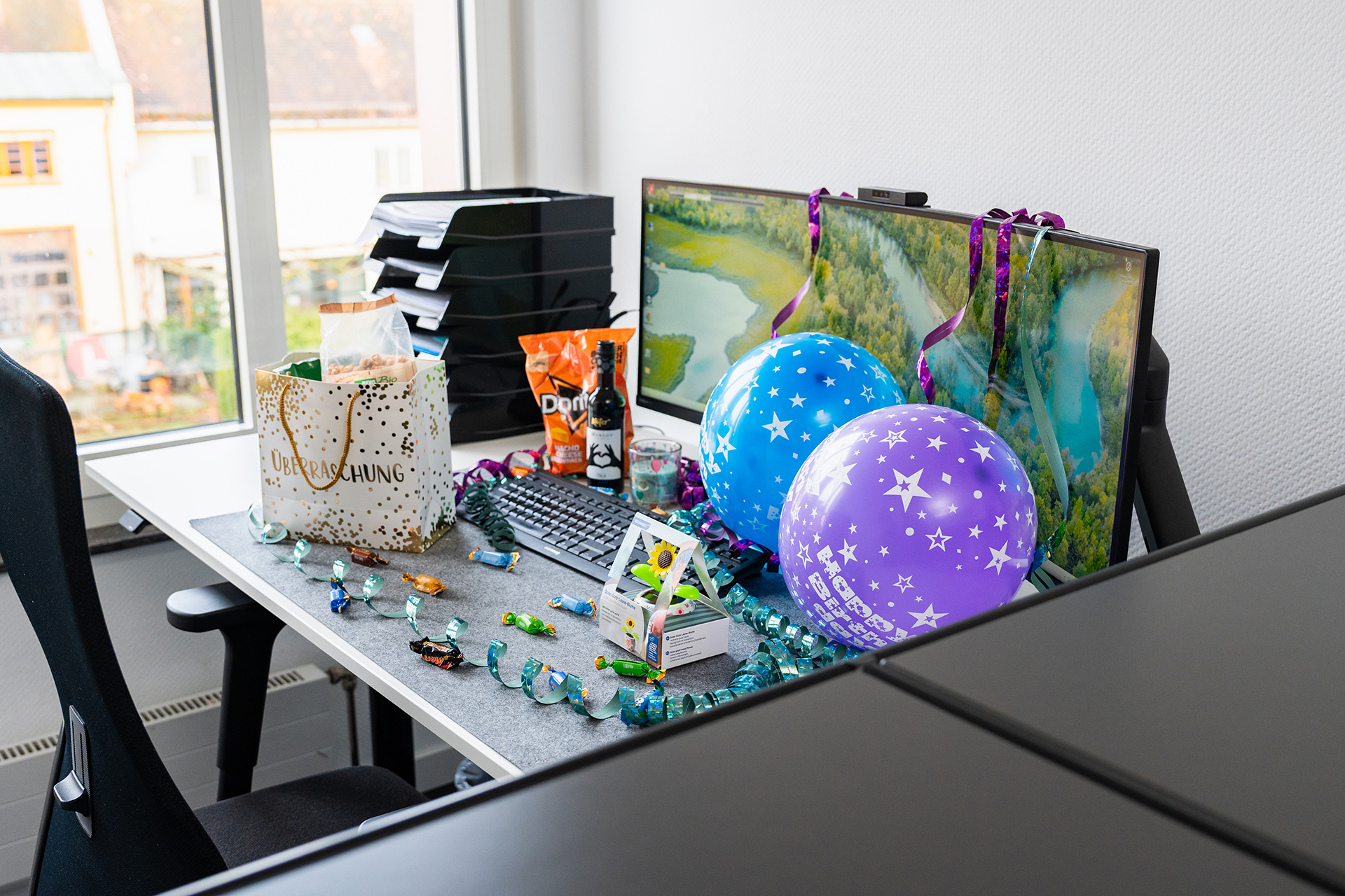 Schreibtisch mit Geschenken, Dekoration und Luftballons in den Raeumen der Steuerberatungsgesellschaft Pauly in Kronberg